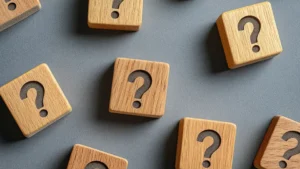 wooden blocks with embossed black question marks on a gray background