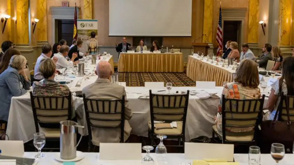 Professional roundtable meeting with FAR organization members discussing policy in an elegant conference room.